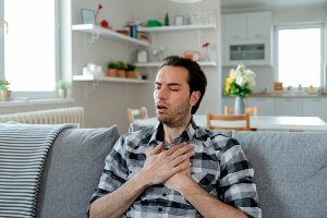 man clutching chest in pain