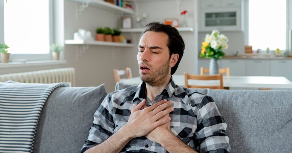 man clutching chest in pain