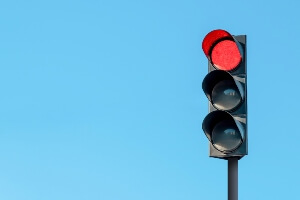 stock image of a red traffic light against a blue sky