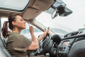 female putting on make-up while driving