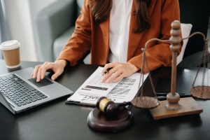 Someone sitting at a desk with paperwork and a gravel.