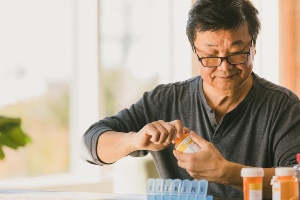 Man putting pills in a container.