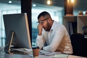 Man tired at his desk.