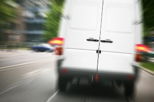 A driver's view of a van's rear on the road.