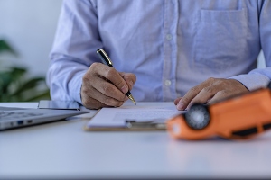 A professional is writing in a notebook at a desk.