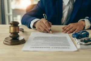 A professional signing paper work at a desk.