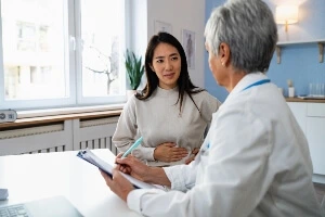 A person holding their stomach during a medical consultation.