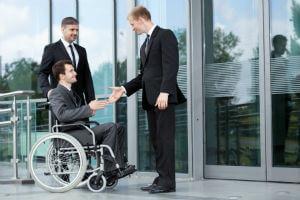 man in wheelchair with attorneys