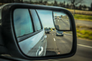 mirror showing cars in highway
